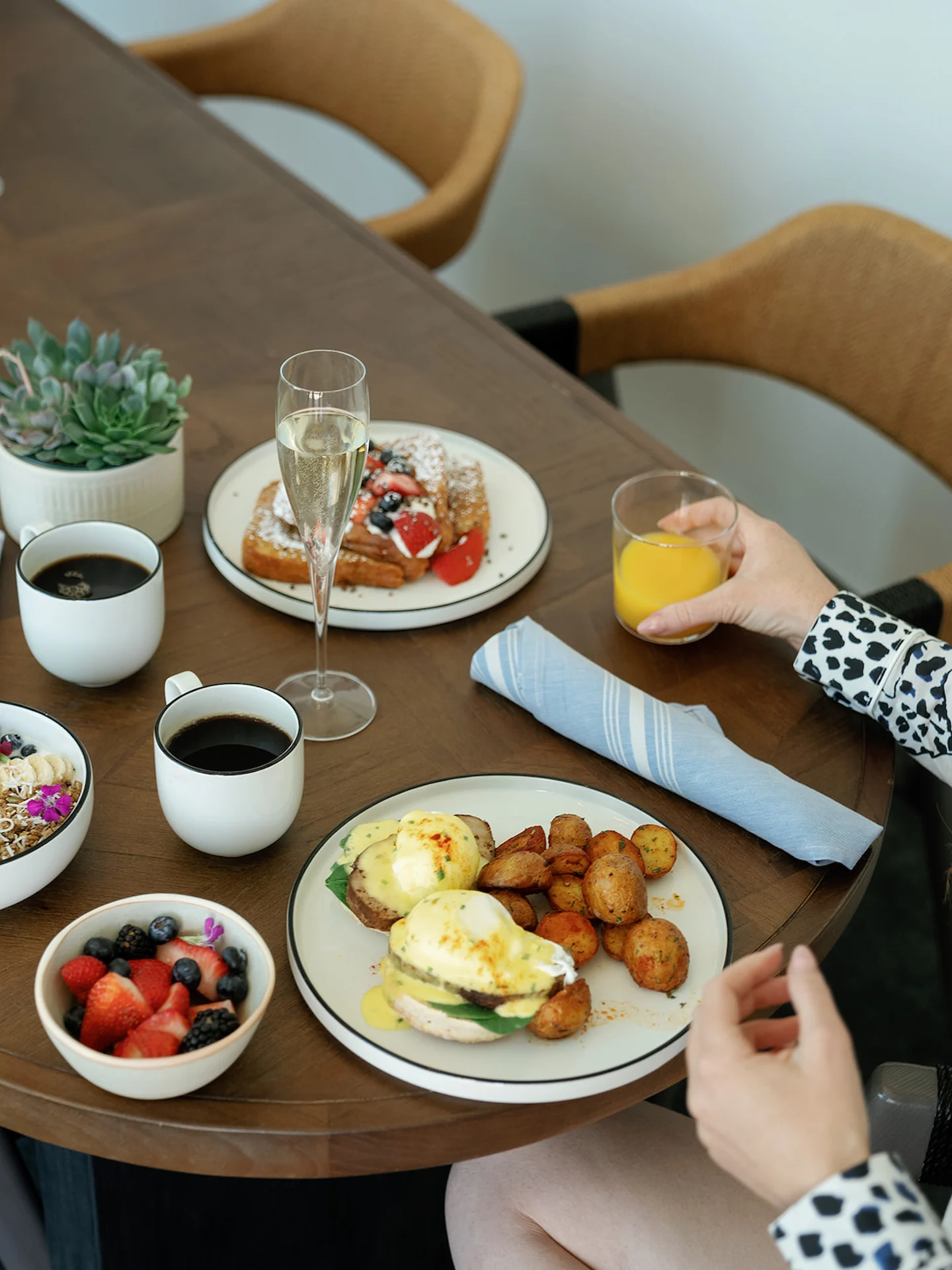 A woman enjoying her breakfast in the hotel room, savoring a delightful meal in a relaxed atmosphere